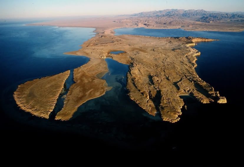 The Ras Mohammed headland from the air, a sand peninsula reaching into deep blue water.